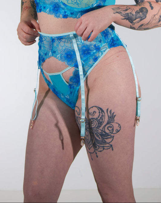Woman wearing a blue patterned lingerie against a white background
