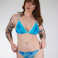 Woman wearing a blue bikini with floral pattern against a white background
