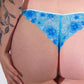 Blue floral lace underwear worn by a person on a white background