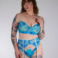 Woman wearing a blue patterned lingerie set against a plain background