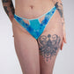 Person wearing blue patterned underwear with tattoos on arms and legs.