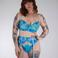Woman wearing a blue floral lingerie set against a plain background