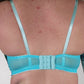 Person wearing a blue bra and underwear set with a plain background