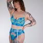 Person wearing a blue floral lingerie set against a plain background